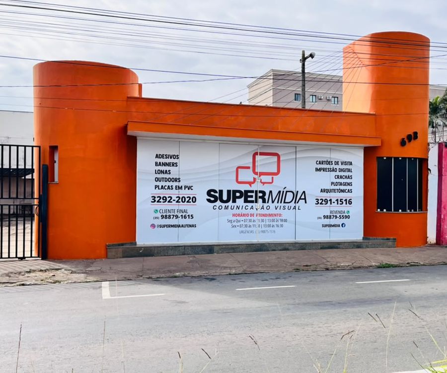Fachada da SuperMídia na Avenida José Paulino da Costa: prédio laranja com duas torres cilíndricas e o letreiro da empresa entre elas